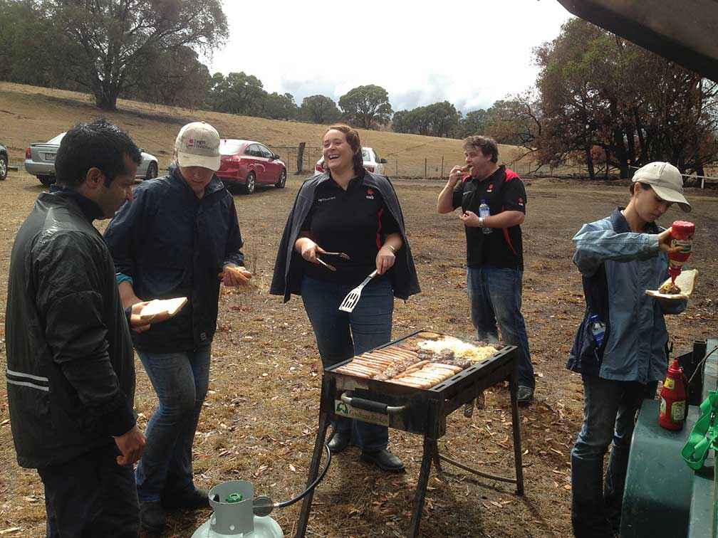 Volunteers from National Australia Bank take a break from removing burnt fences on Wayne Potter’s property at Kilmore in March 2014.