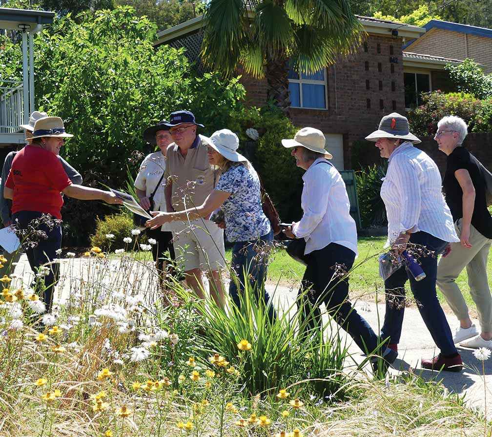 Volunteer Joanne Diver (in red) conducting a tour of her habitat garden in November last year.